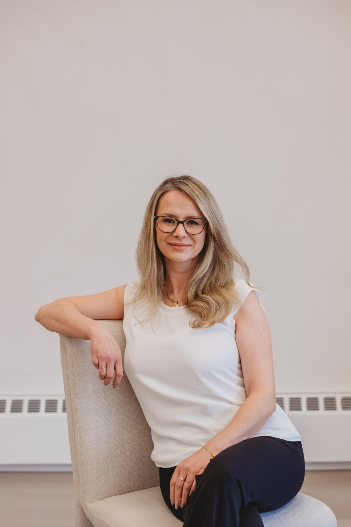 Sarah Hope, a clinical counsellor in St. Catharines, smiling warmly in a cream linen chair